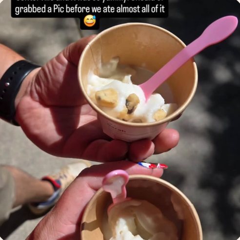 A customer holding a cup of Swirld soft serve with cookie dough topping